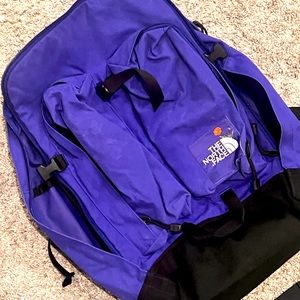 Dark purple Northface backpack that includes a padded slot for your laptop.